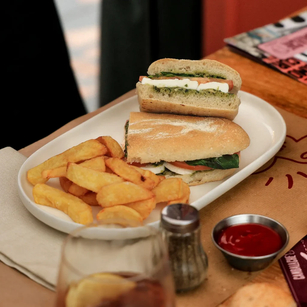 SANDWICH CAPRESSE, CON QUESO, ALBAHACA,TOMATE,PESTO CON PAPAS FRITAS.